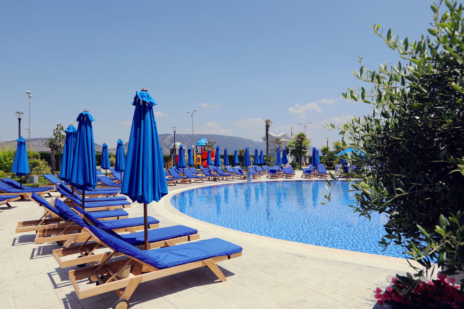 a pool with blue chairs and umbrellas