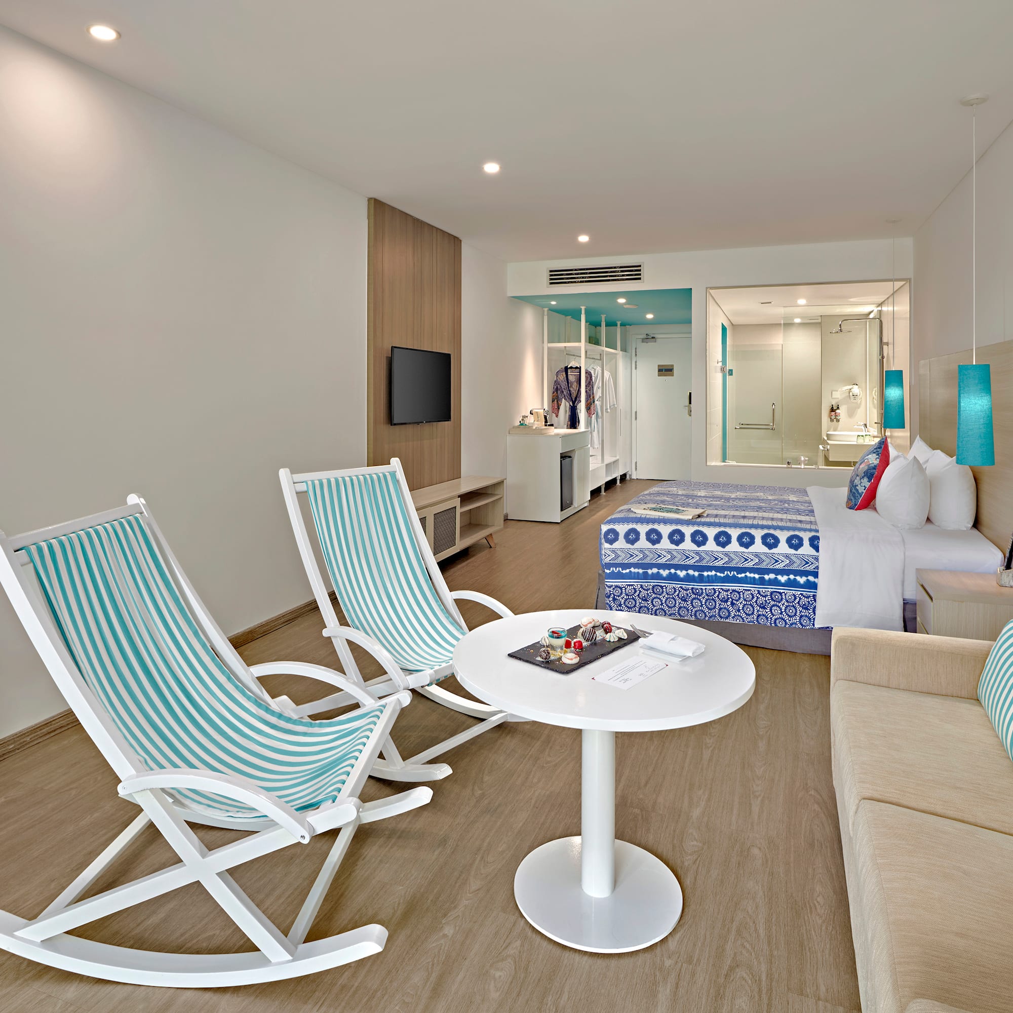 a room with a bed and chairs