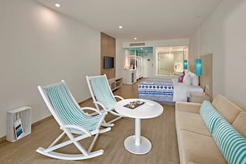 a room with a bed and chairs