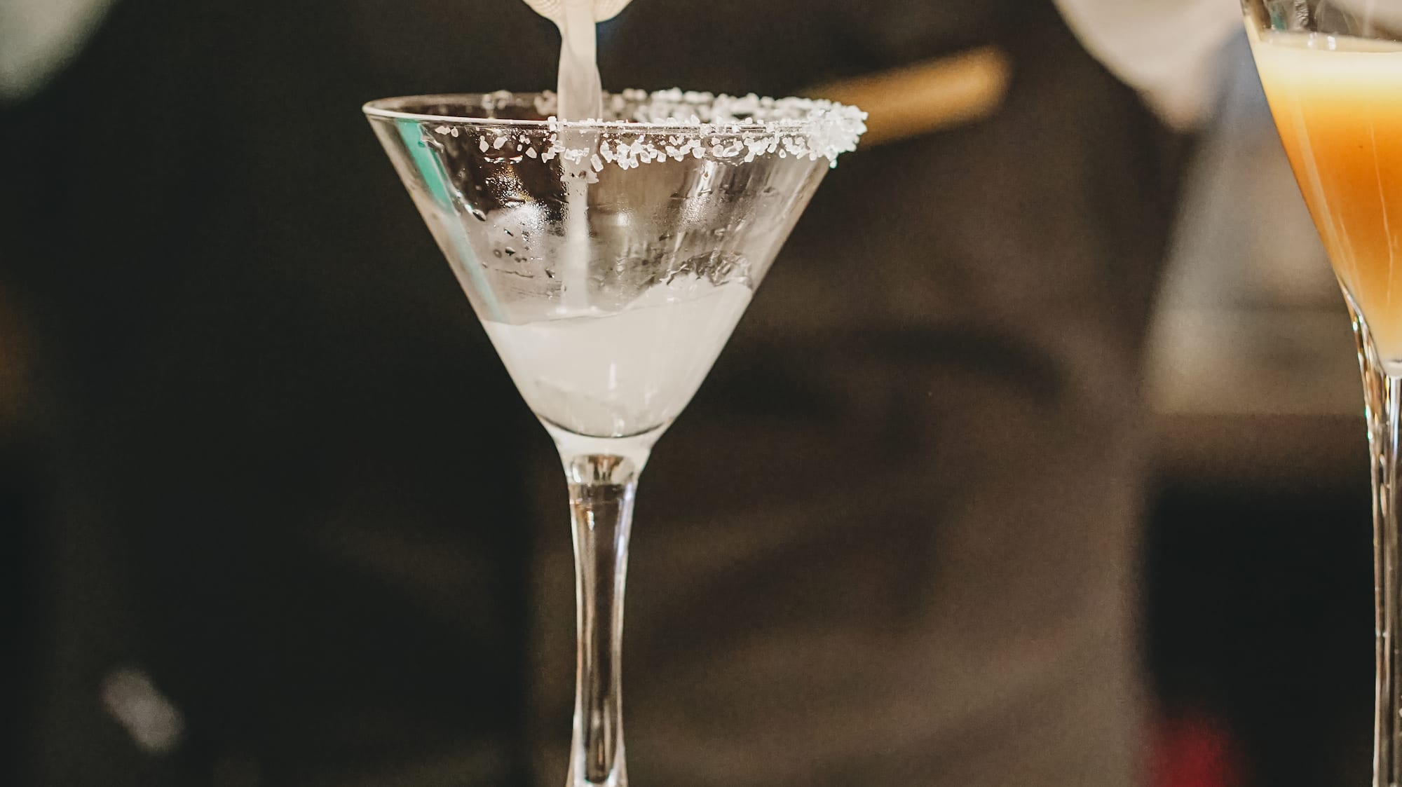 a person pouring liquid into a glass