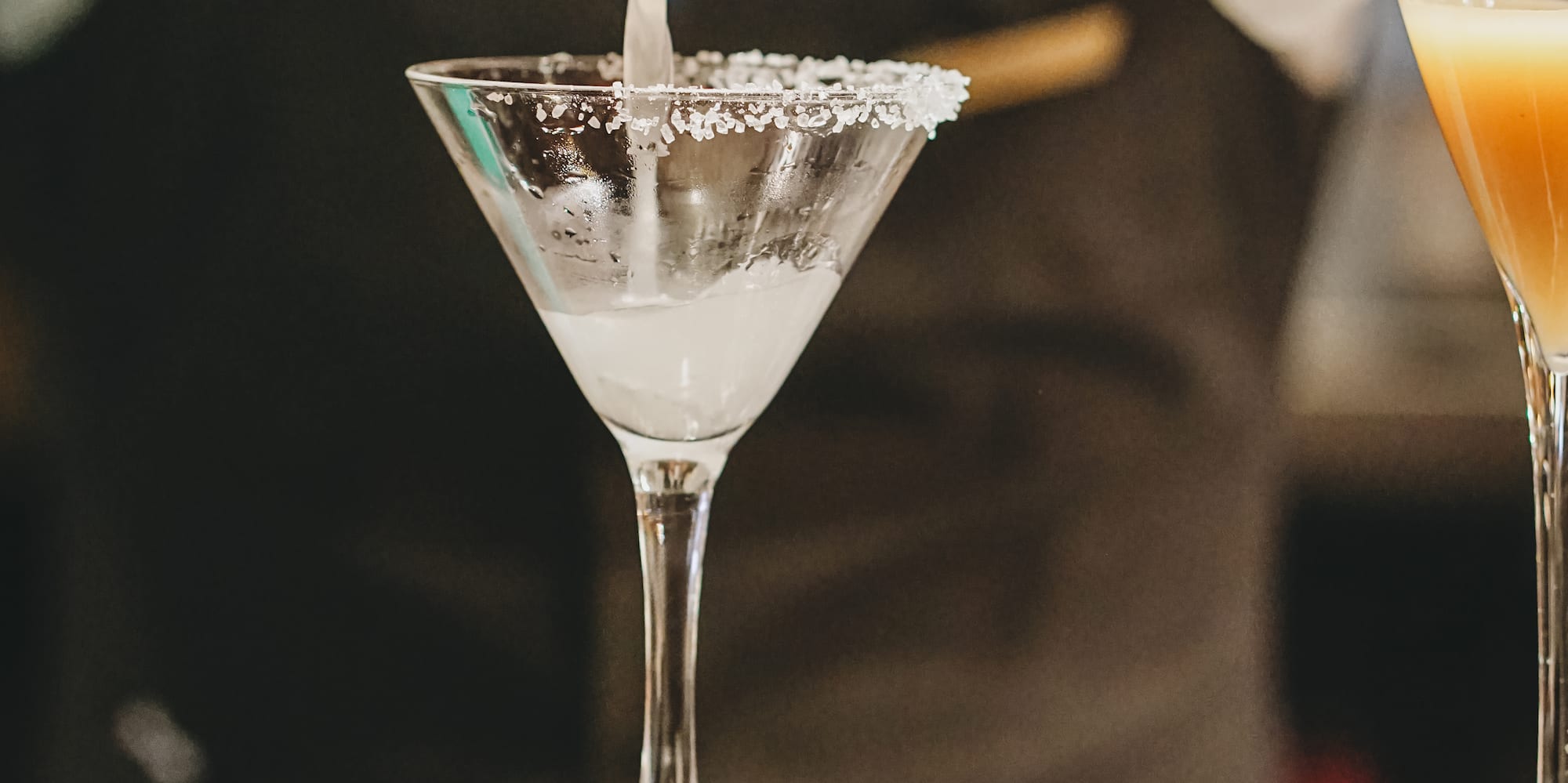 a person pouring liquid into a glass