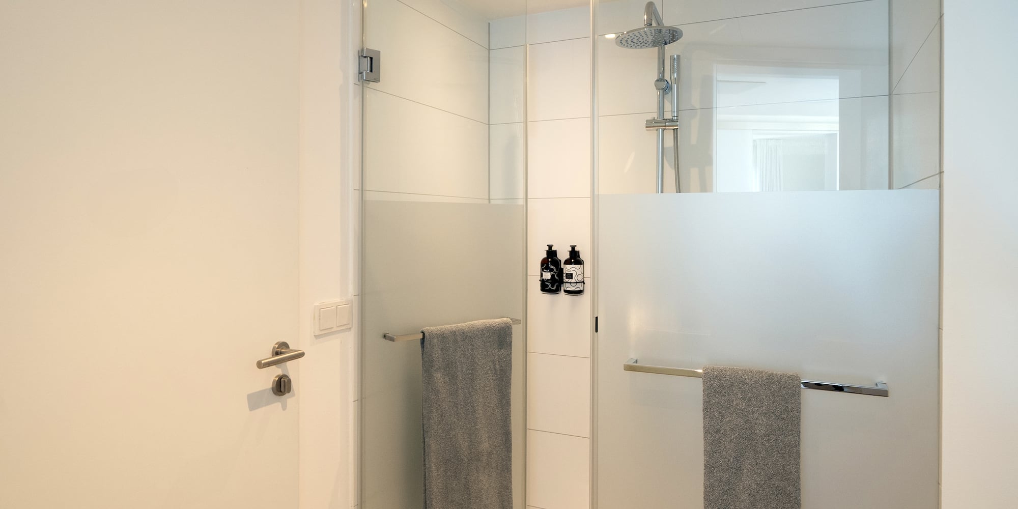 a shower with a glass door and a shower head