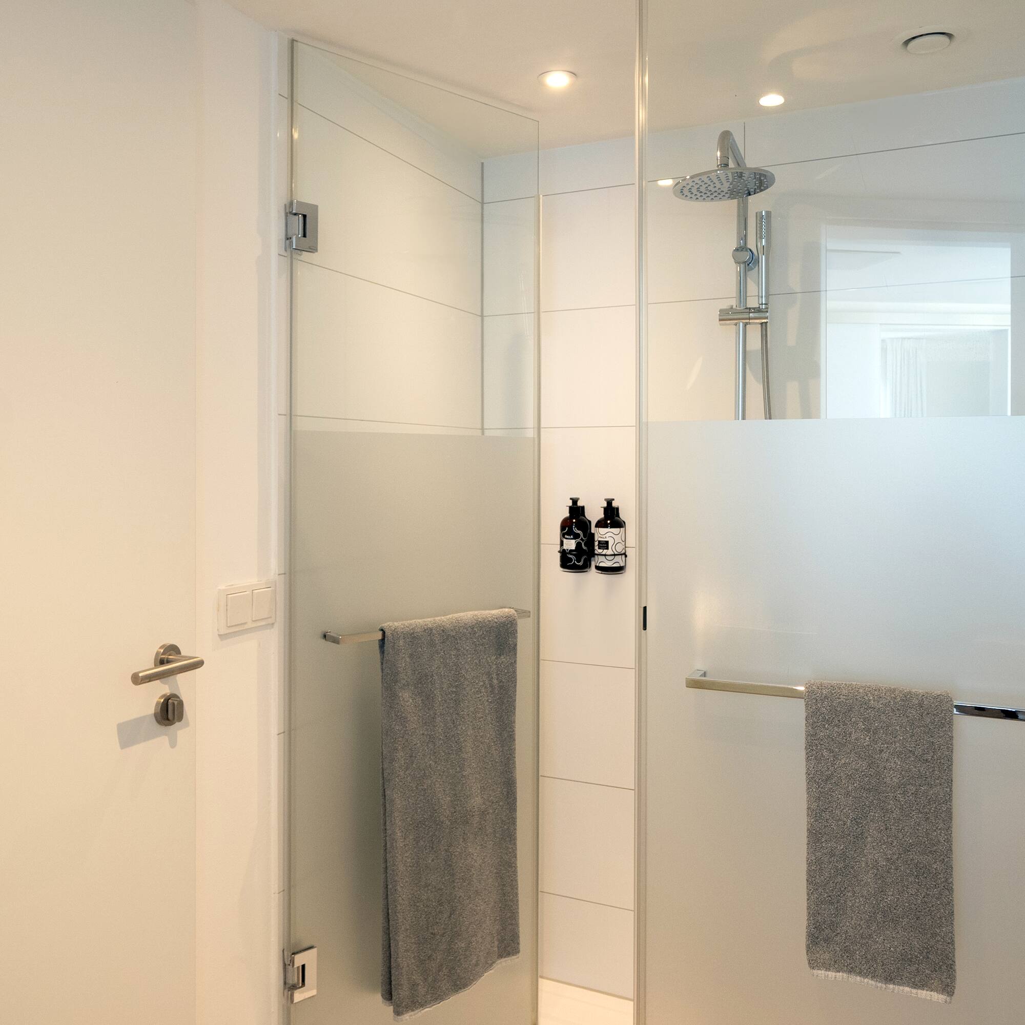 a shower with a glass door and a shower head