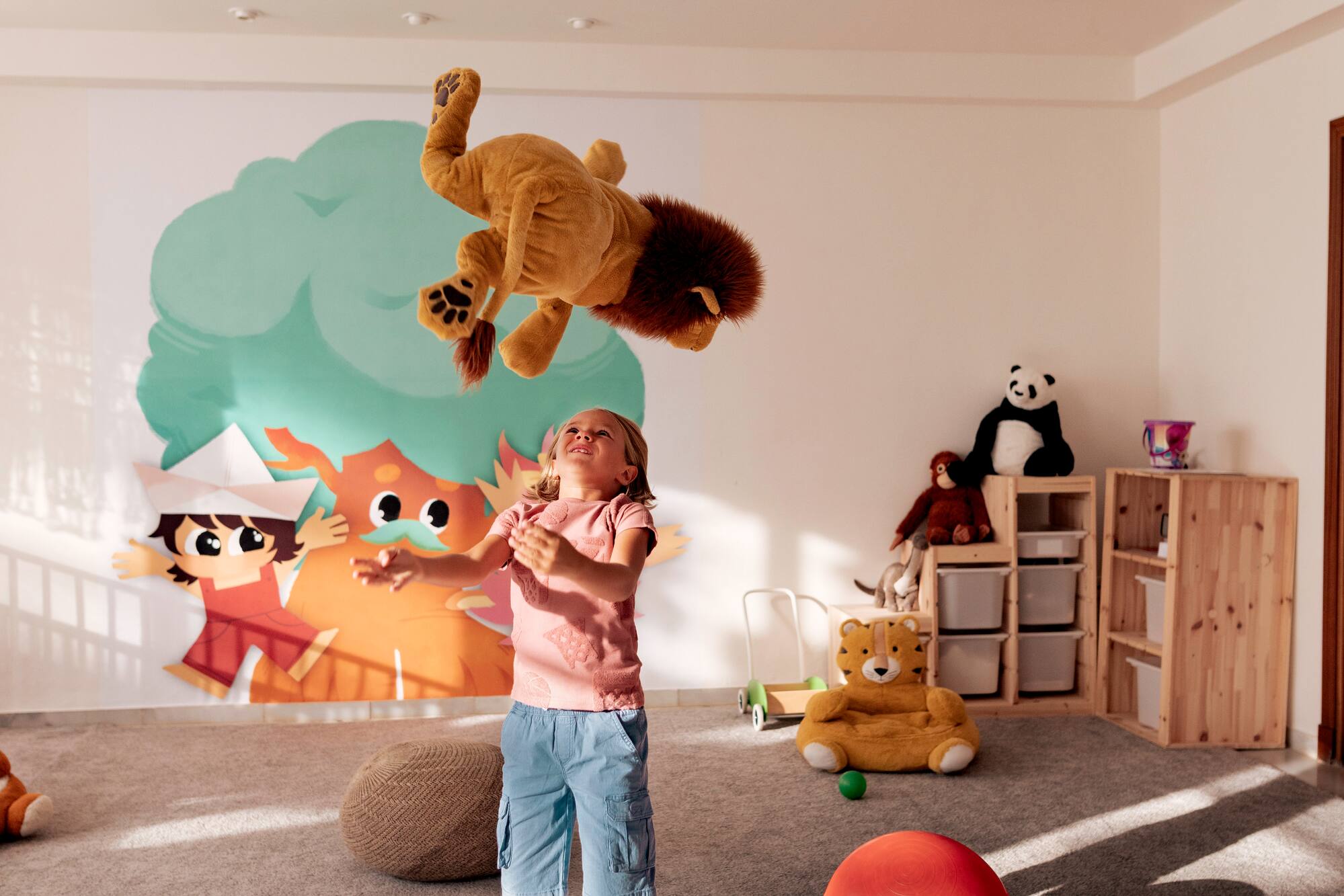 a girl in a room with a stuffed animal