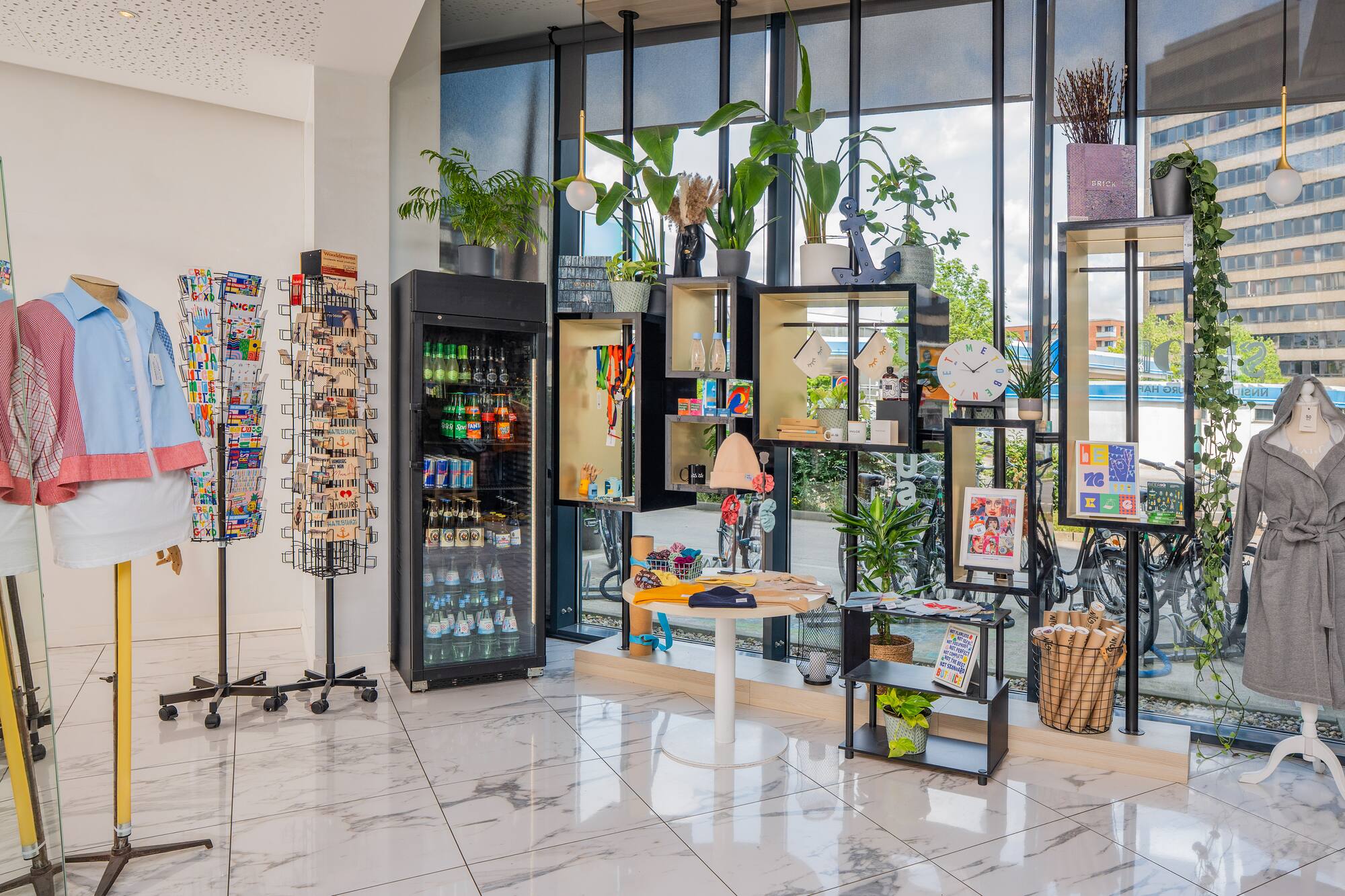Modern hotel gift shop interior with clothing, snacks, postcards, and diverse souvenirs.