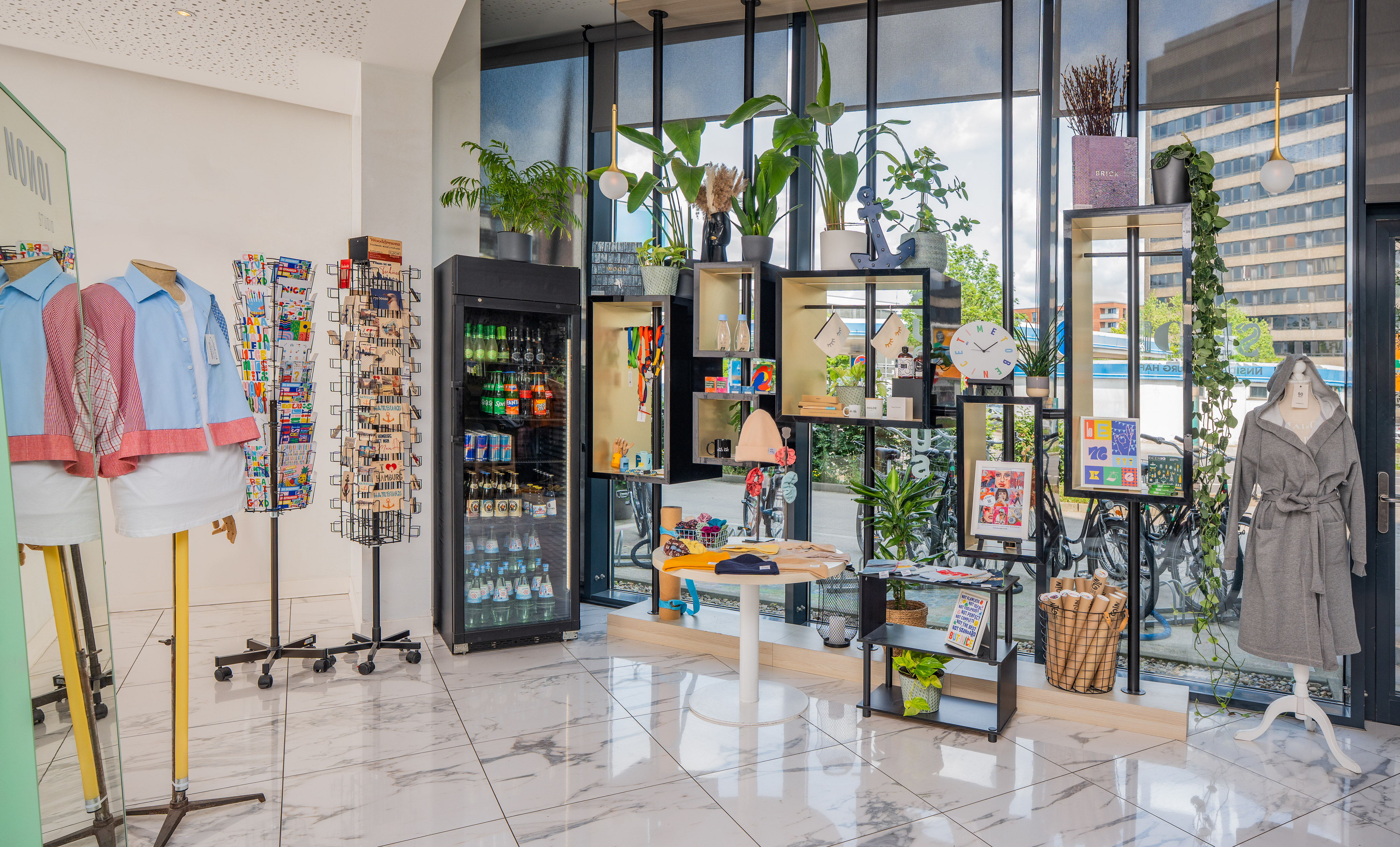 Modern hotel gift shop interior with clothing, snacks, postcards, and diverse souvenirs.