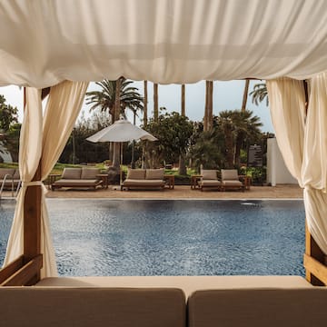 a pool with a white canopy and chairs