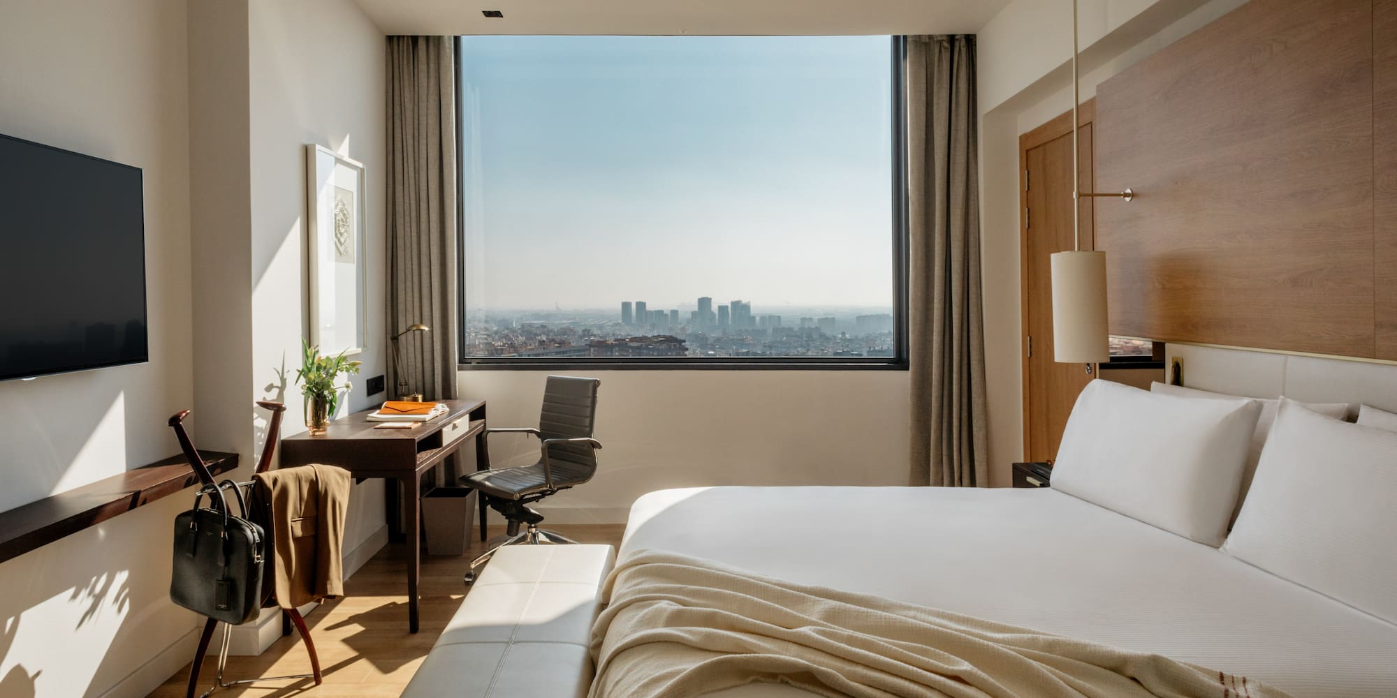 a bedroom with a large window and a large bed