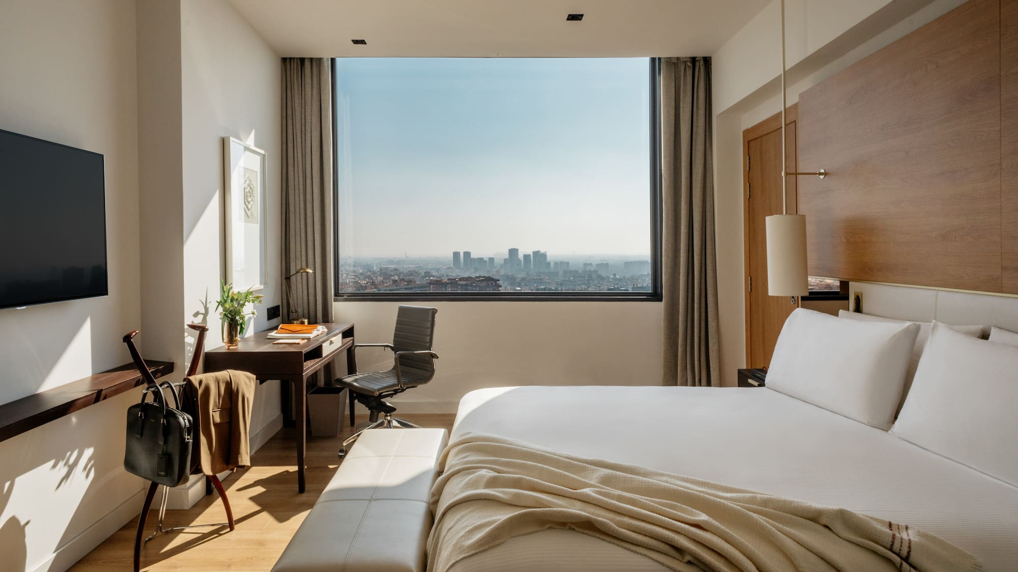 a bedroom with a large window and a large bed