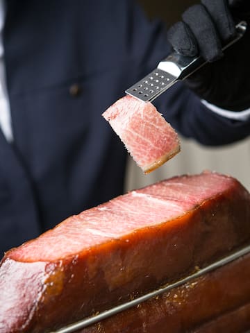 a person holding a piece of meat