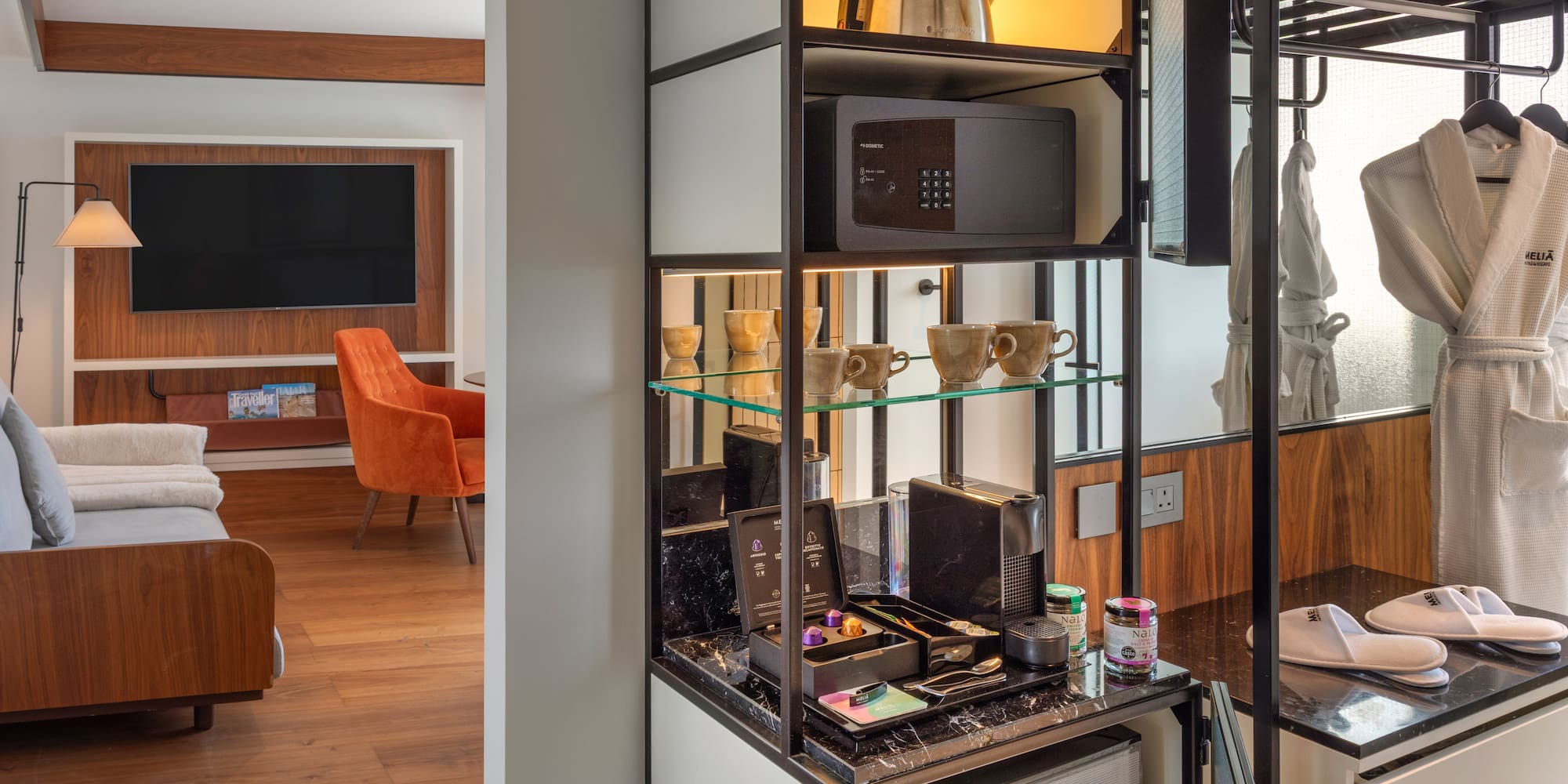Modern hotel room with Nespresso mini-bar, safe, kettle, bathrobes, and TV lounge.