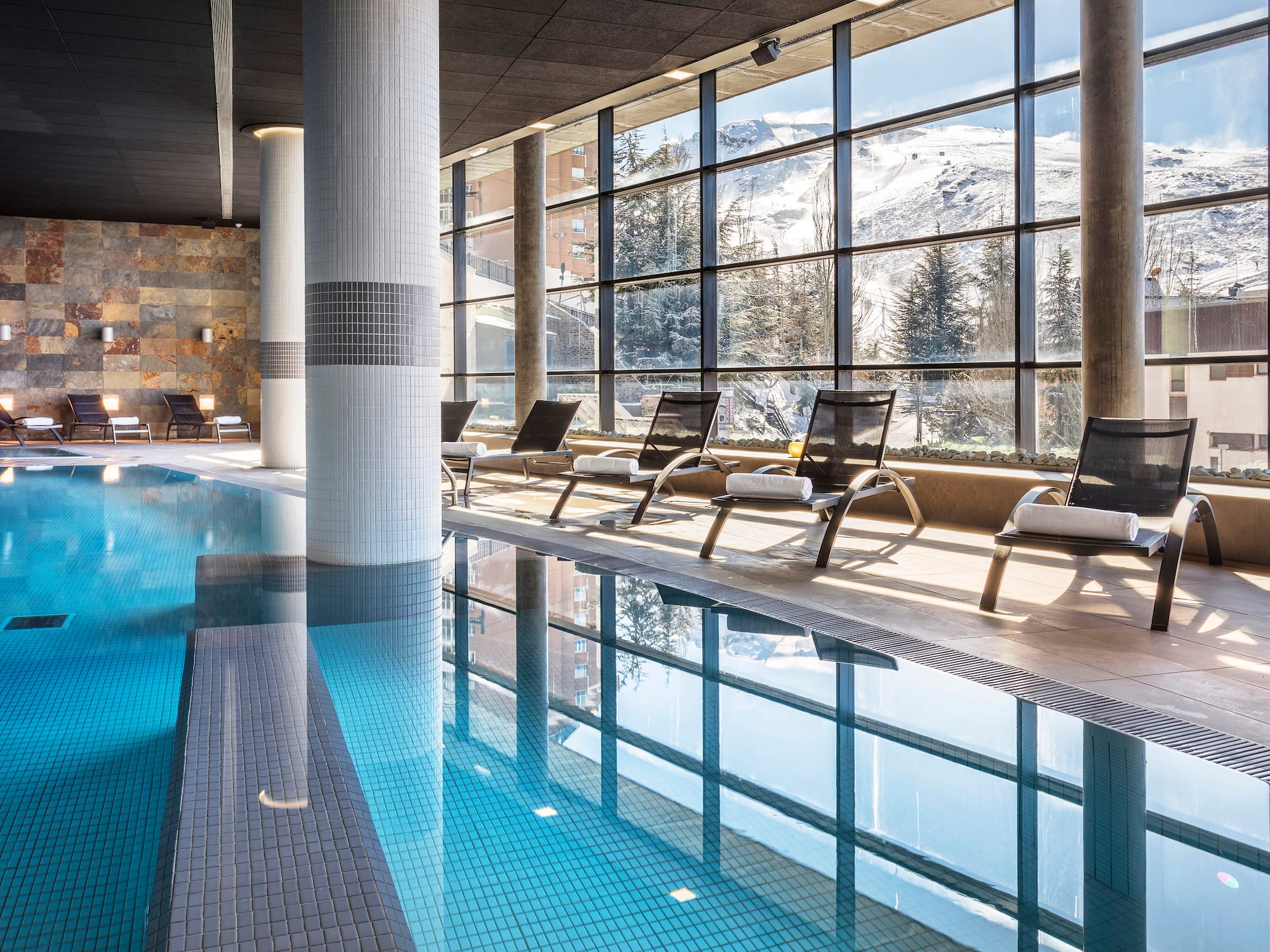 a pool with chairs and a large window