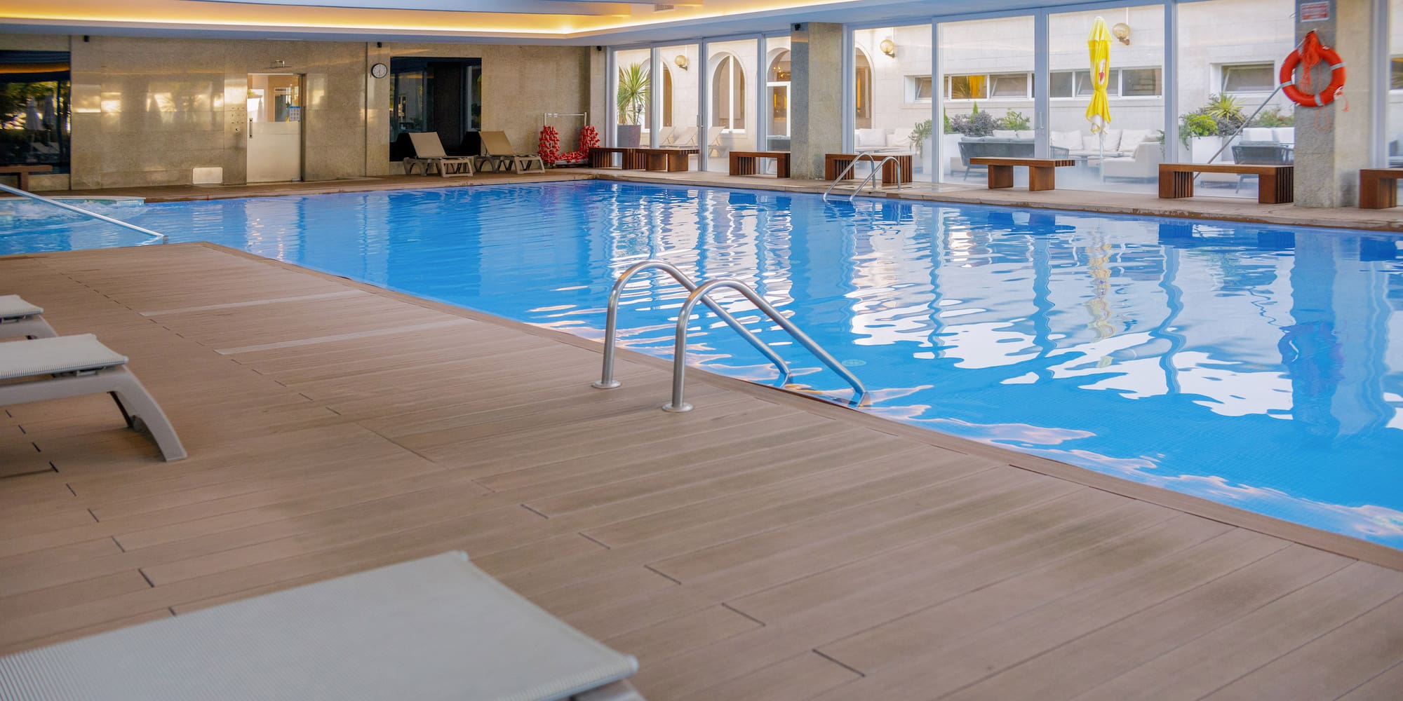 a swimming pool with a deck and chairs