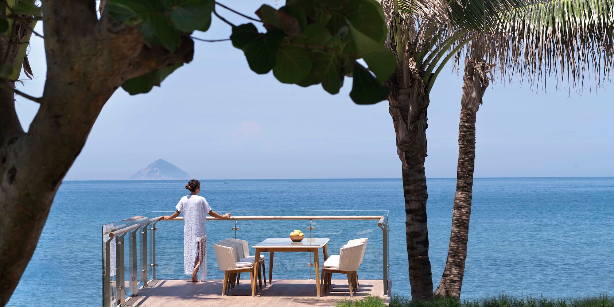 a woman standing on a deck overlooking a body of water