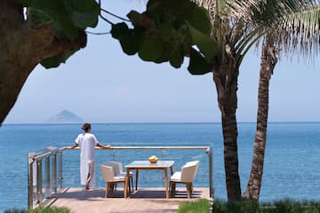 a woman standing on a deck overlooking a body of water