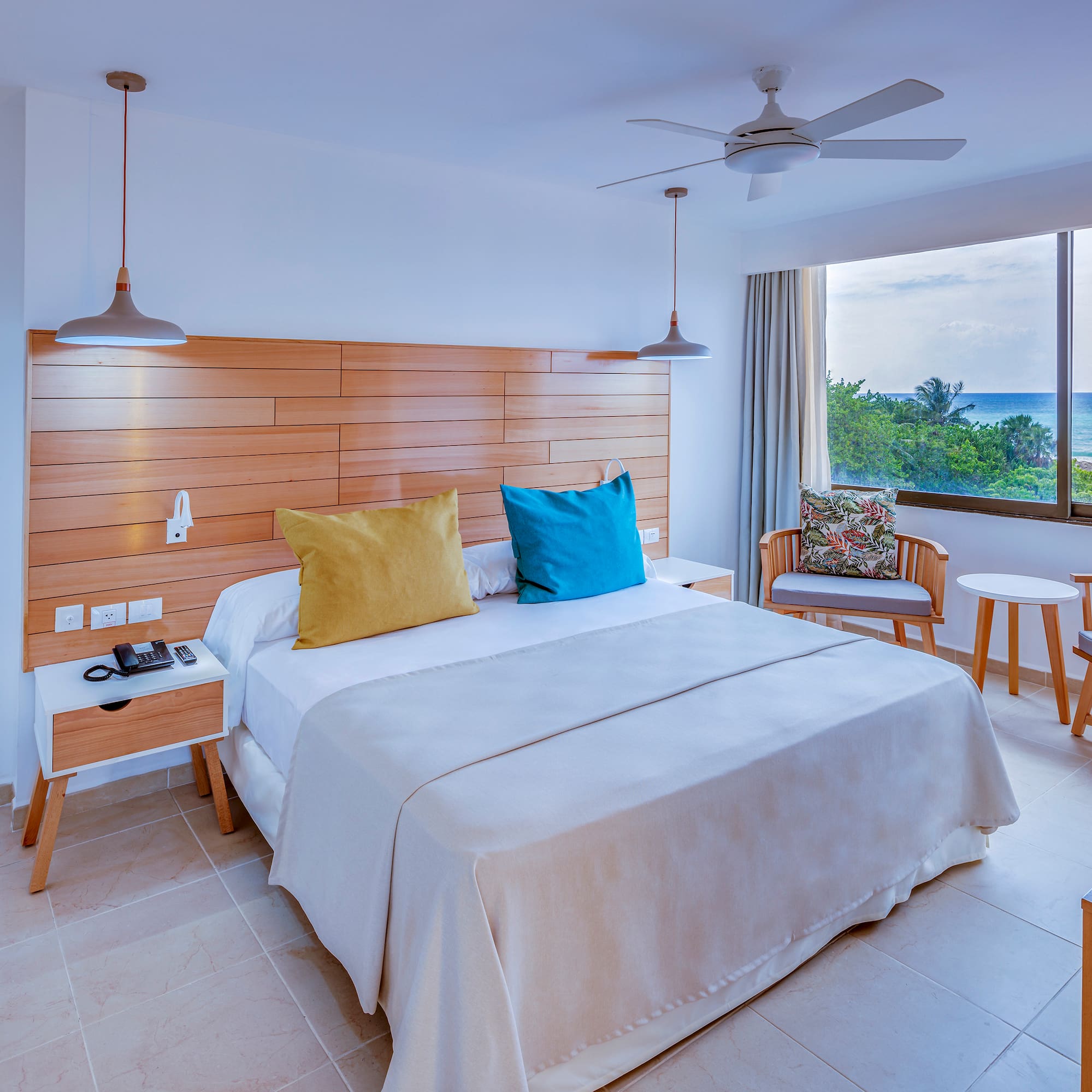 a room with a bed and chairs and a window