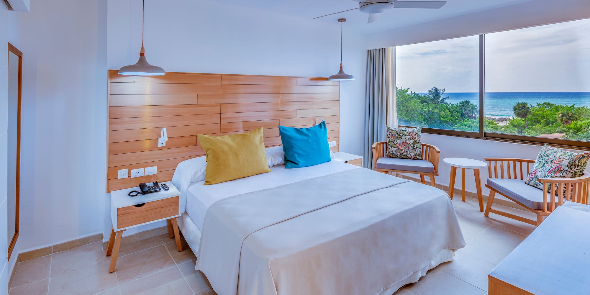 a room with a bed and chairs and a window