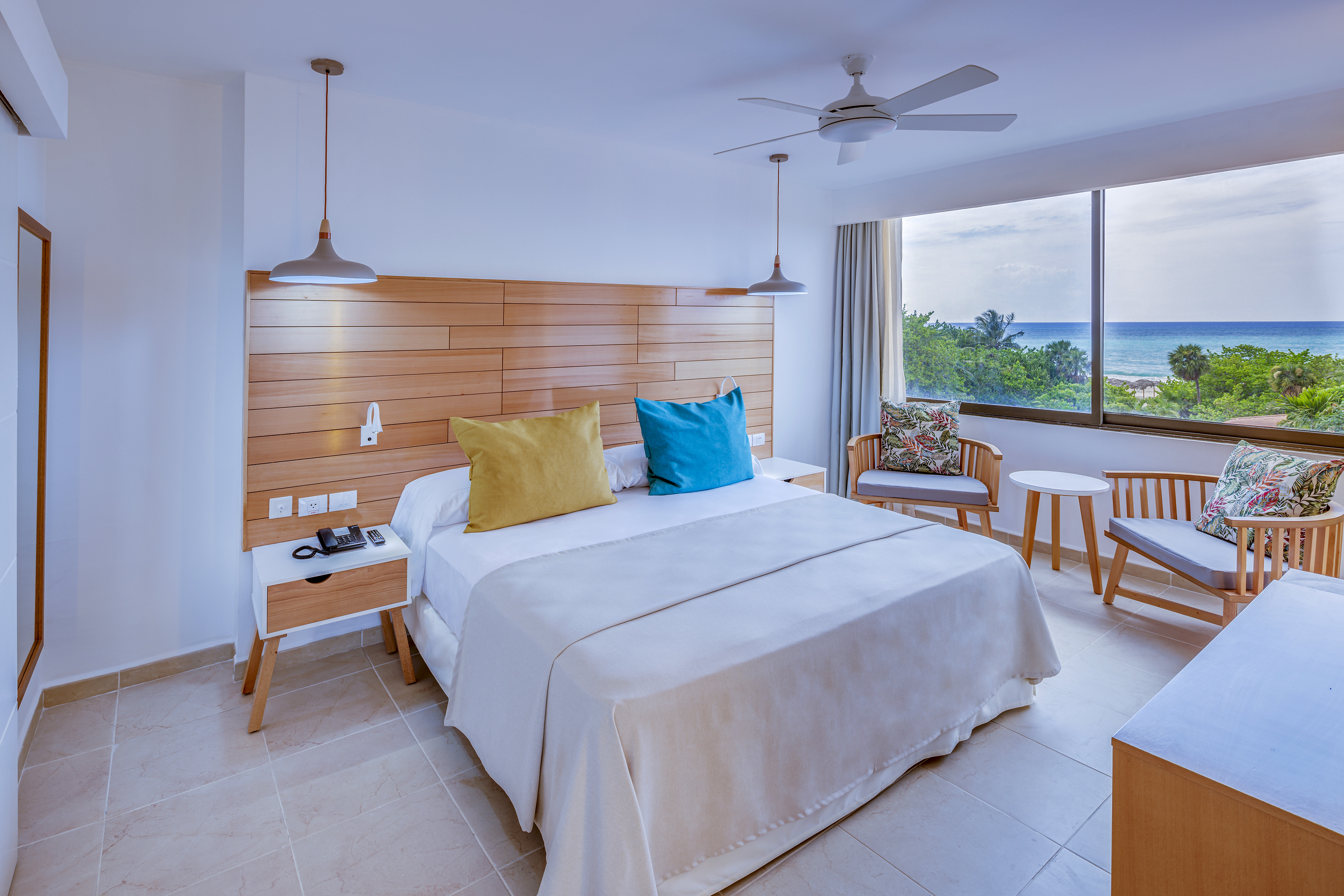 a room with a bed and chairs and a window