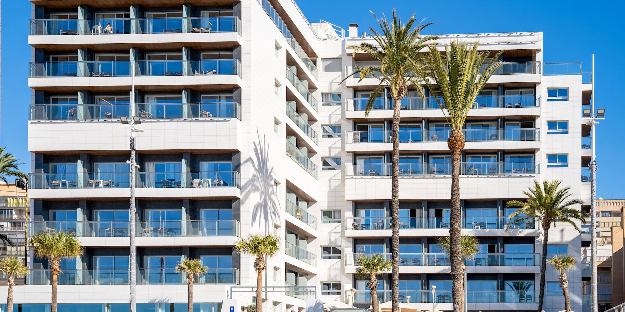a building with palm trees and people in front