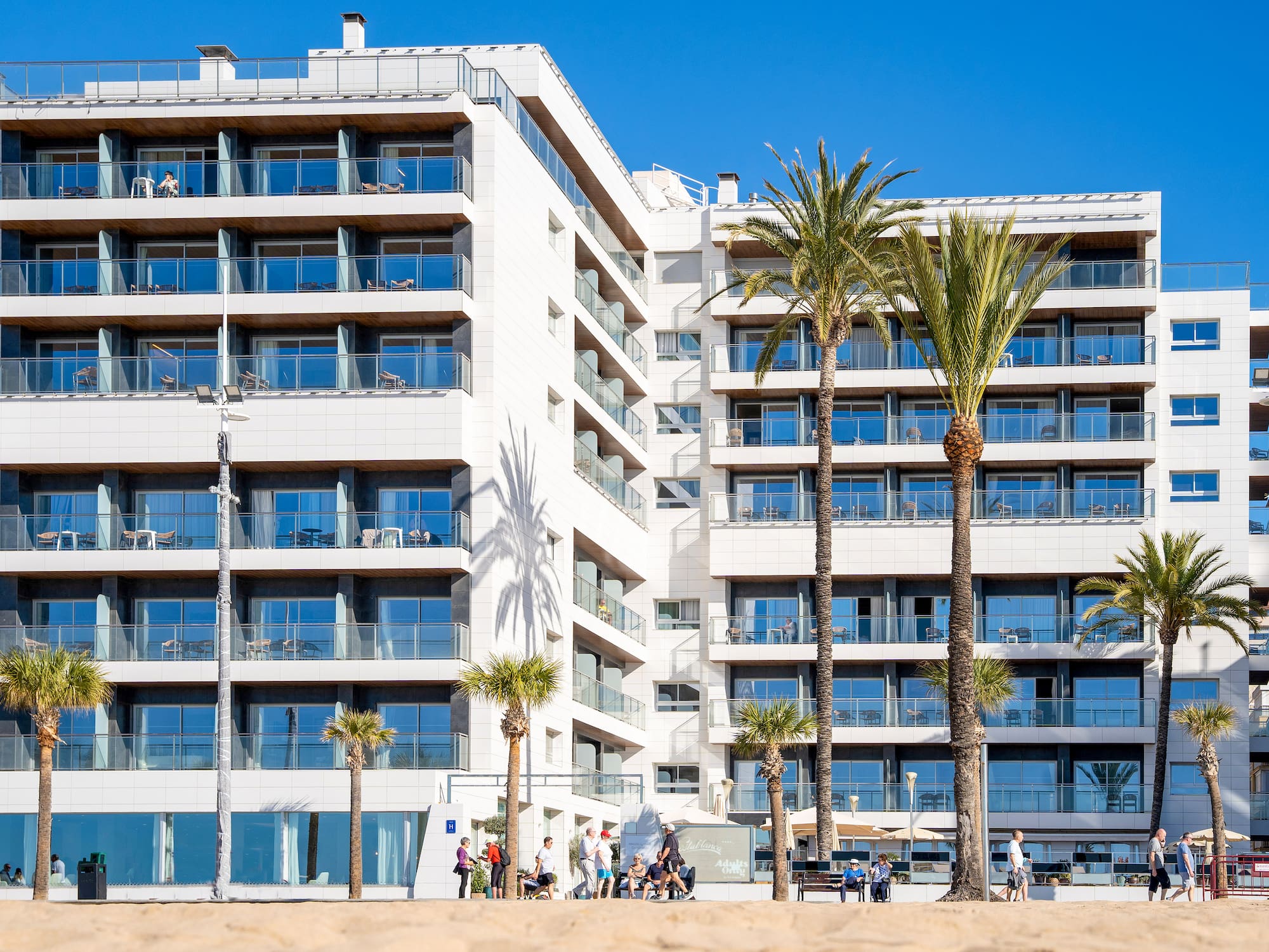 a building with palm trees and people in front