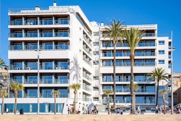 a building with palm trees and people in front