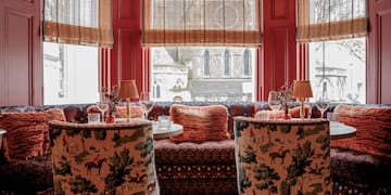 a room with a couch and tables with chairs and a couch