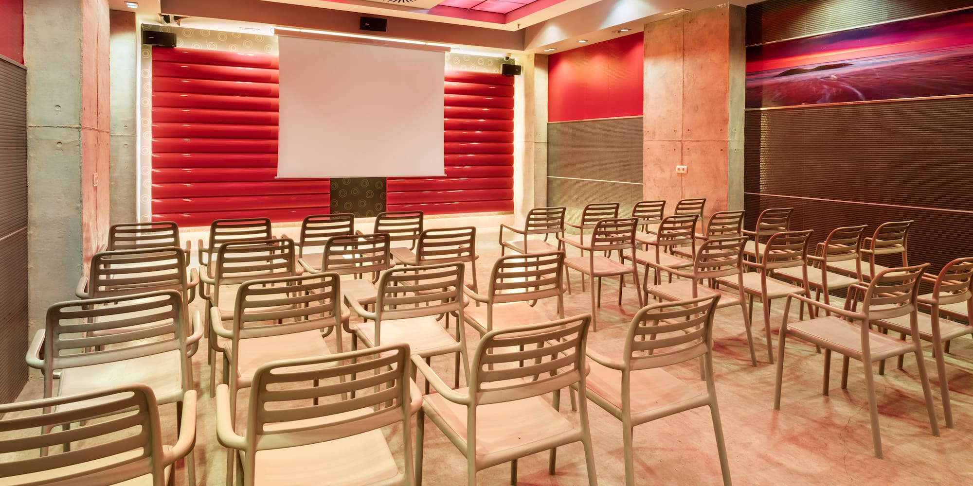 Empty modern conference room with chairs, projection screen, and red accent walls.