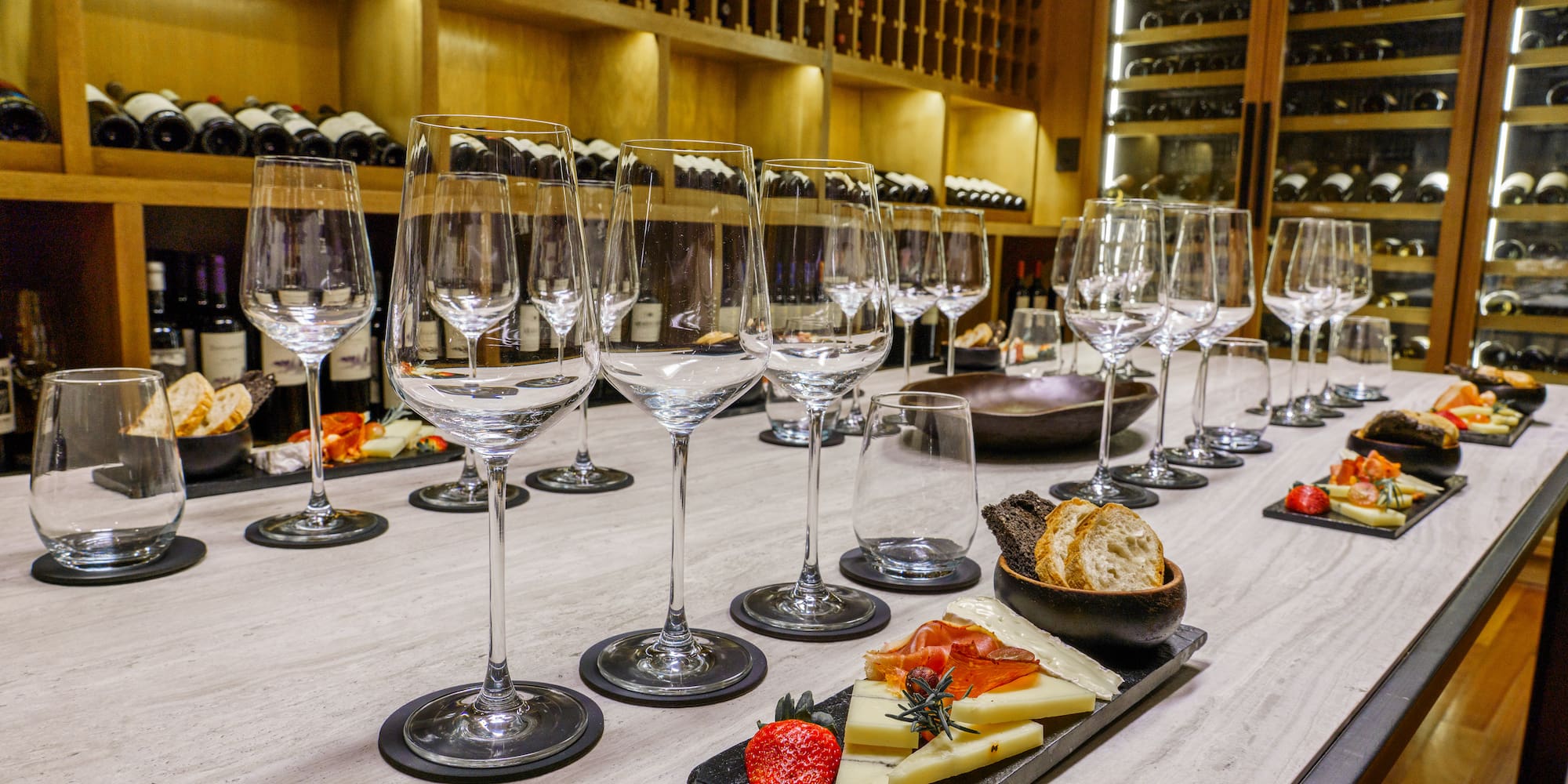a table with wine glasses and cheese on it