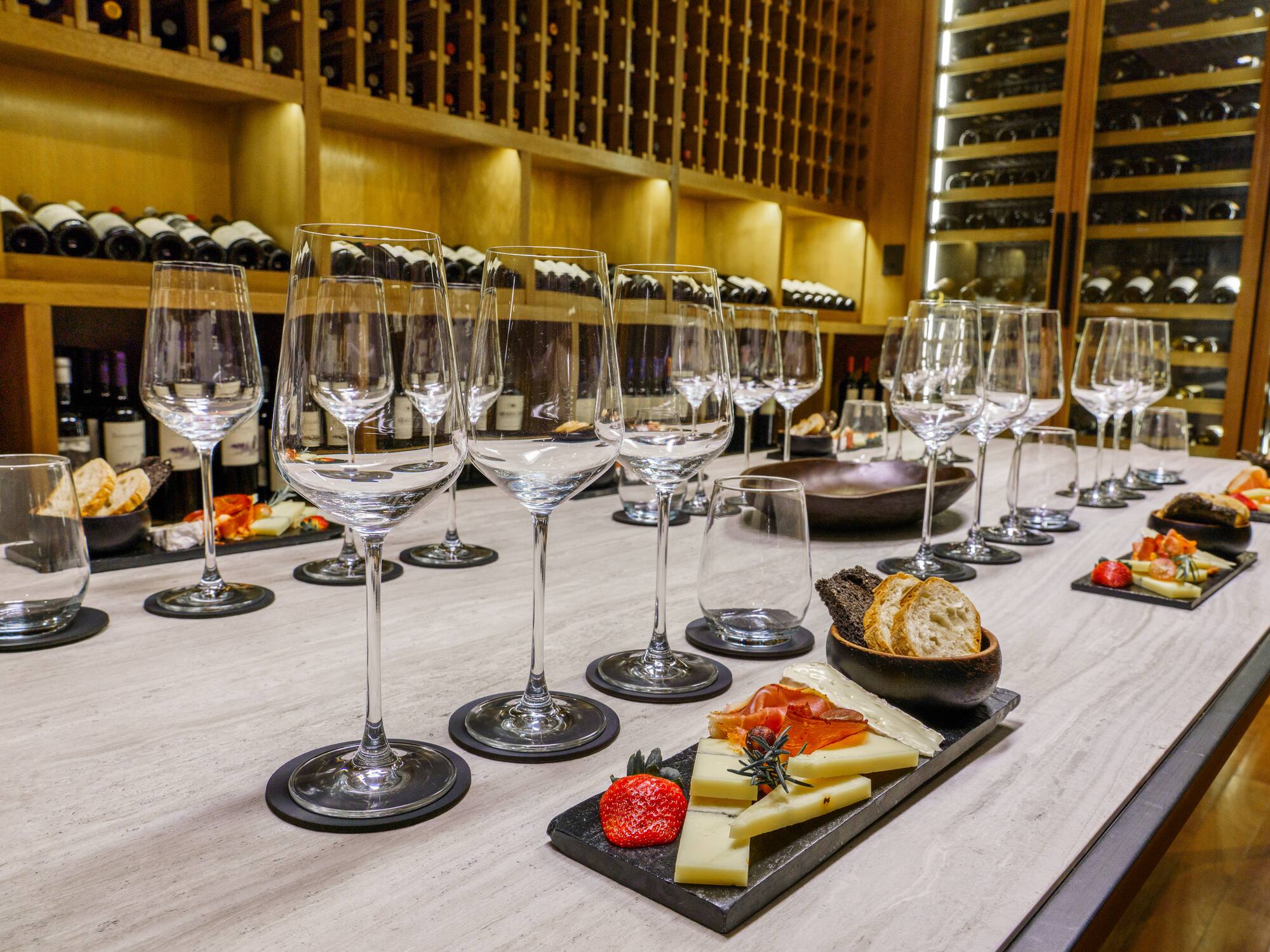 a table with wine glasses and cheese on it