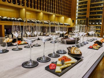 a table with wine glasses and cheese on it