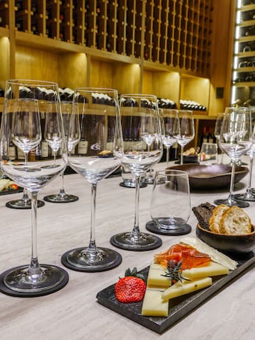 a table with wine glasses and cheese on it