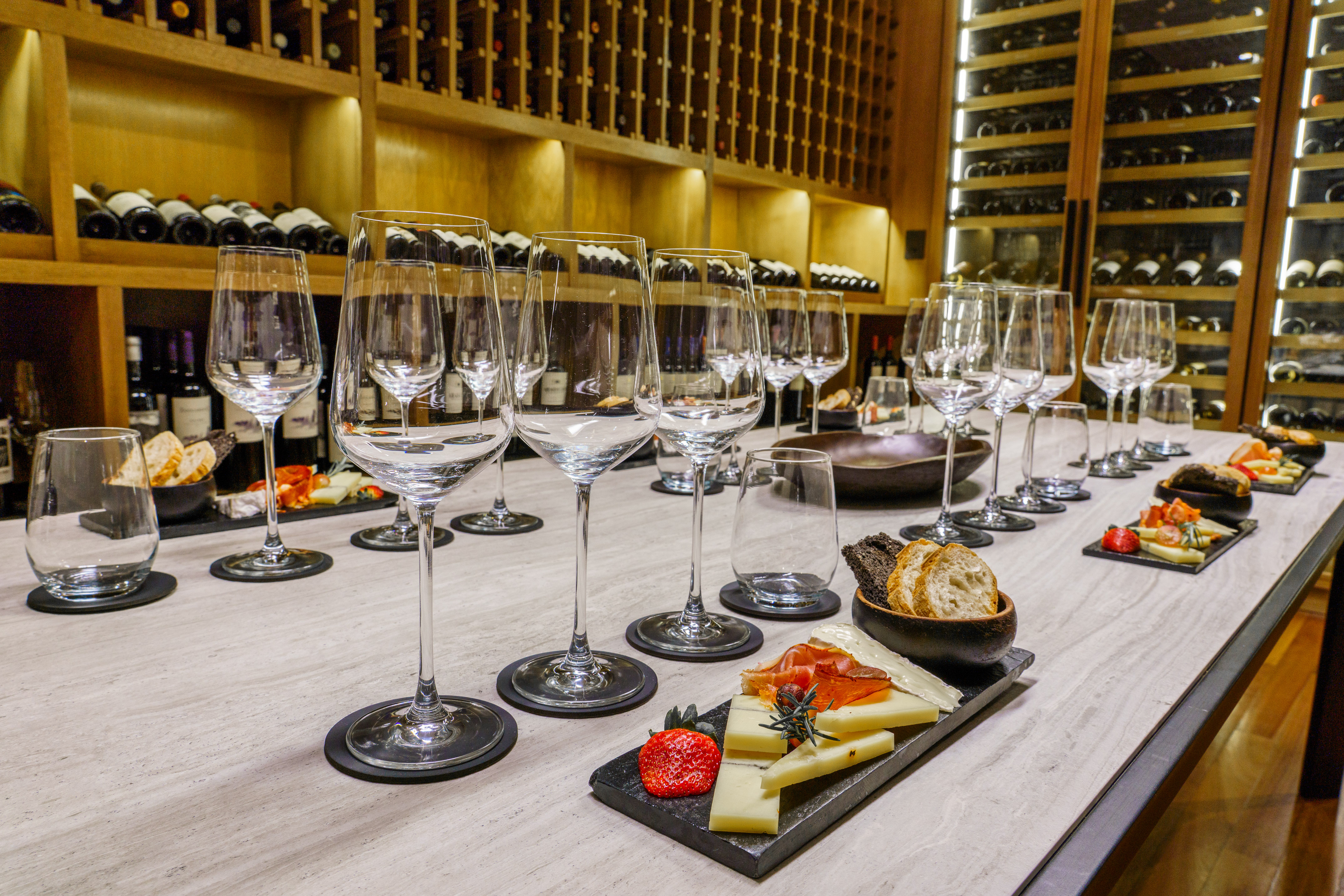 a table with wine glasses and cheese on it