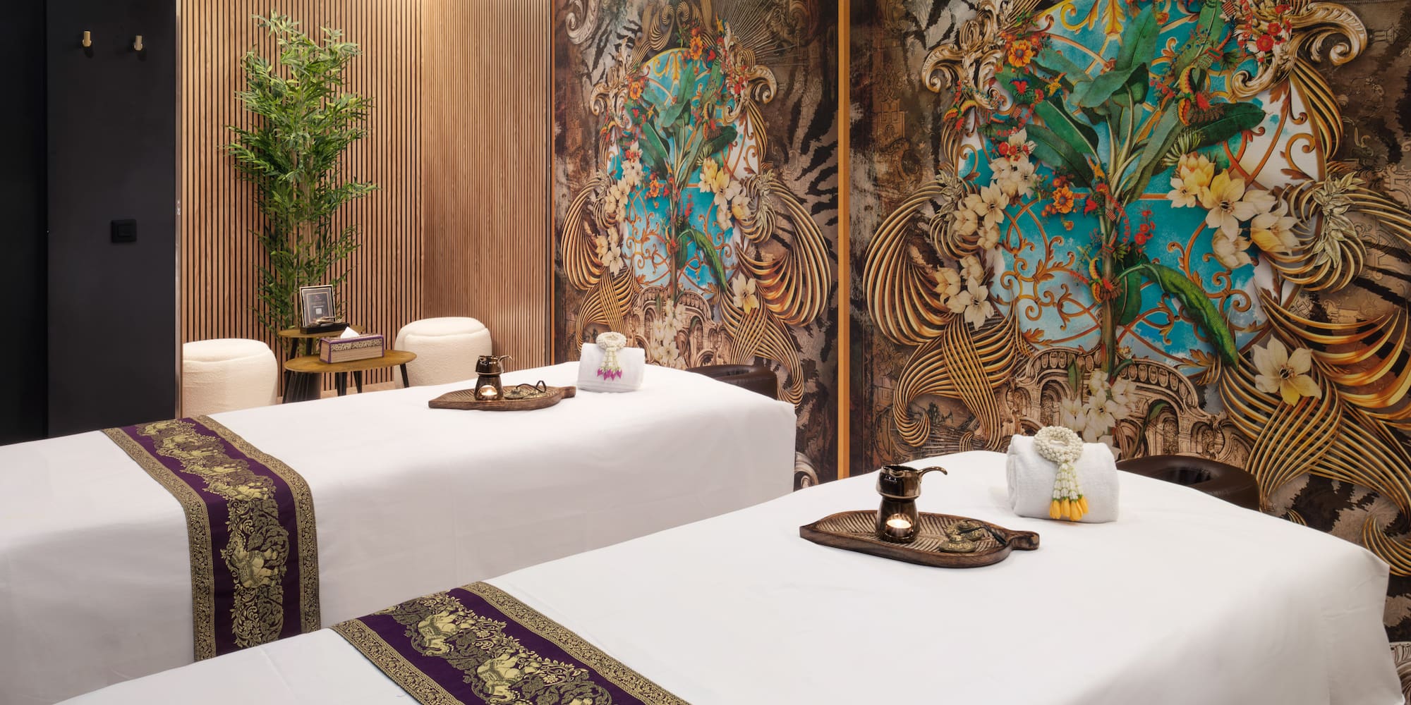 a room with white beds and a wall with floral designs