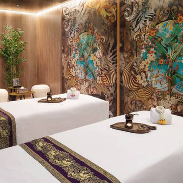a room with white beds and a wall with floral designs