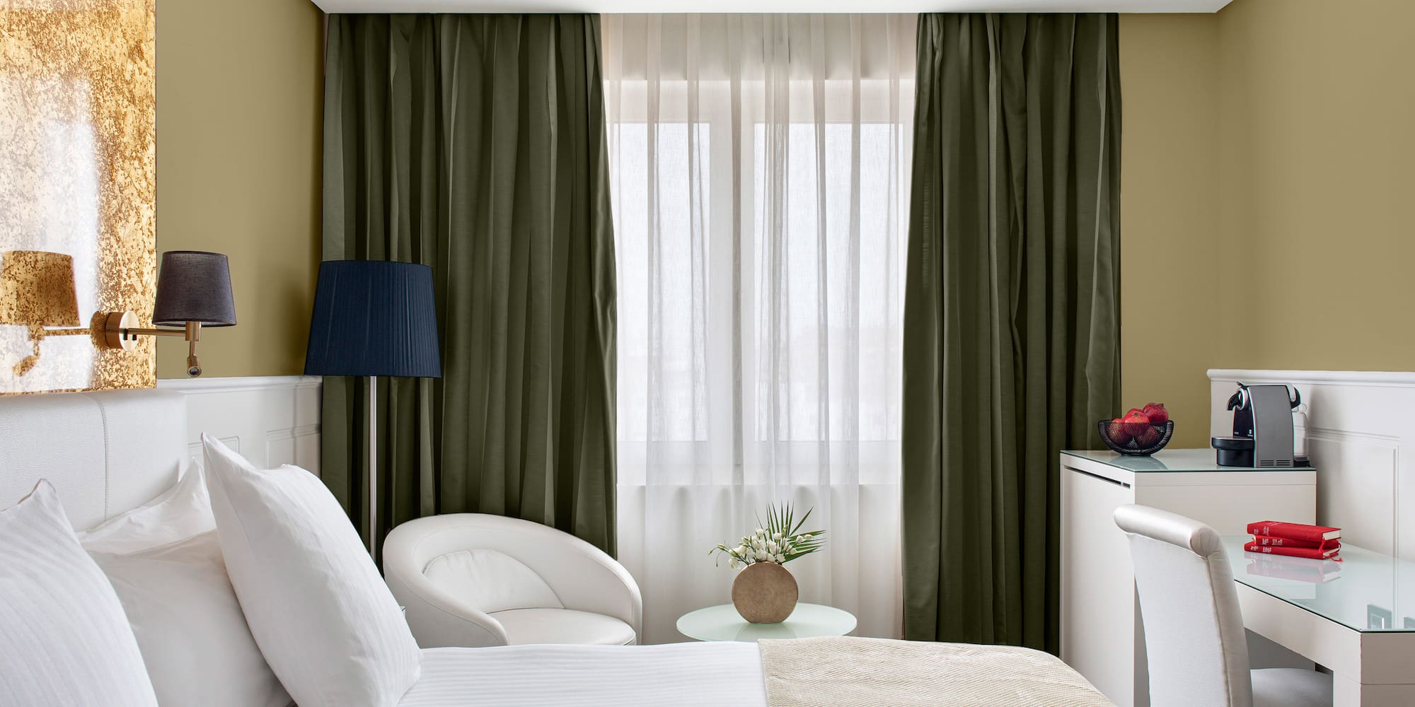 a room with two beds and a table with a lamp and a plant