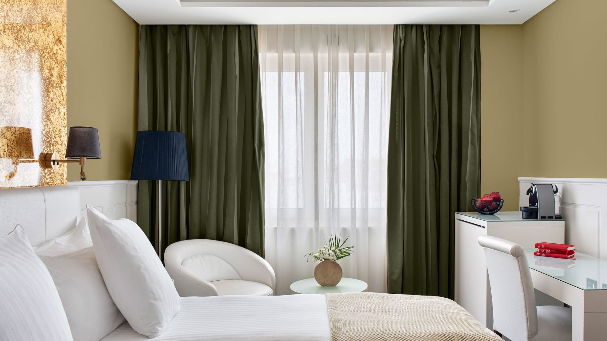 a room with two beds and a table with a lamp and a plant