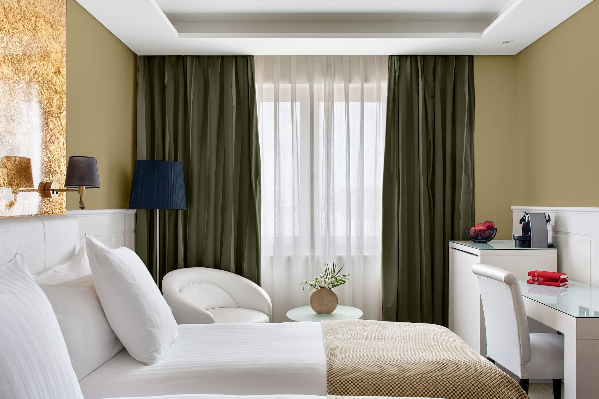 a room with two beds and a table with a lamp and a plant