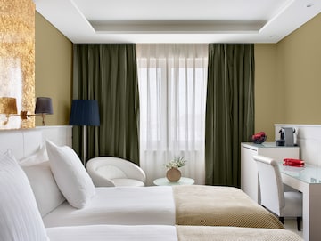 a room with two beds and a table with a lamp and a plant