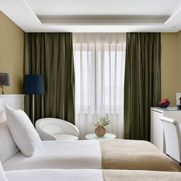 a room with two beds and a table with a lamp and a plant