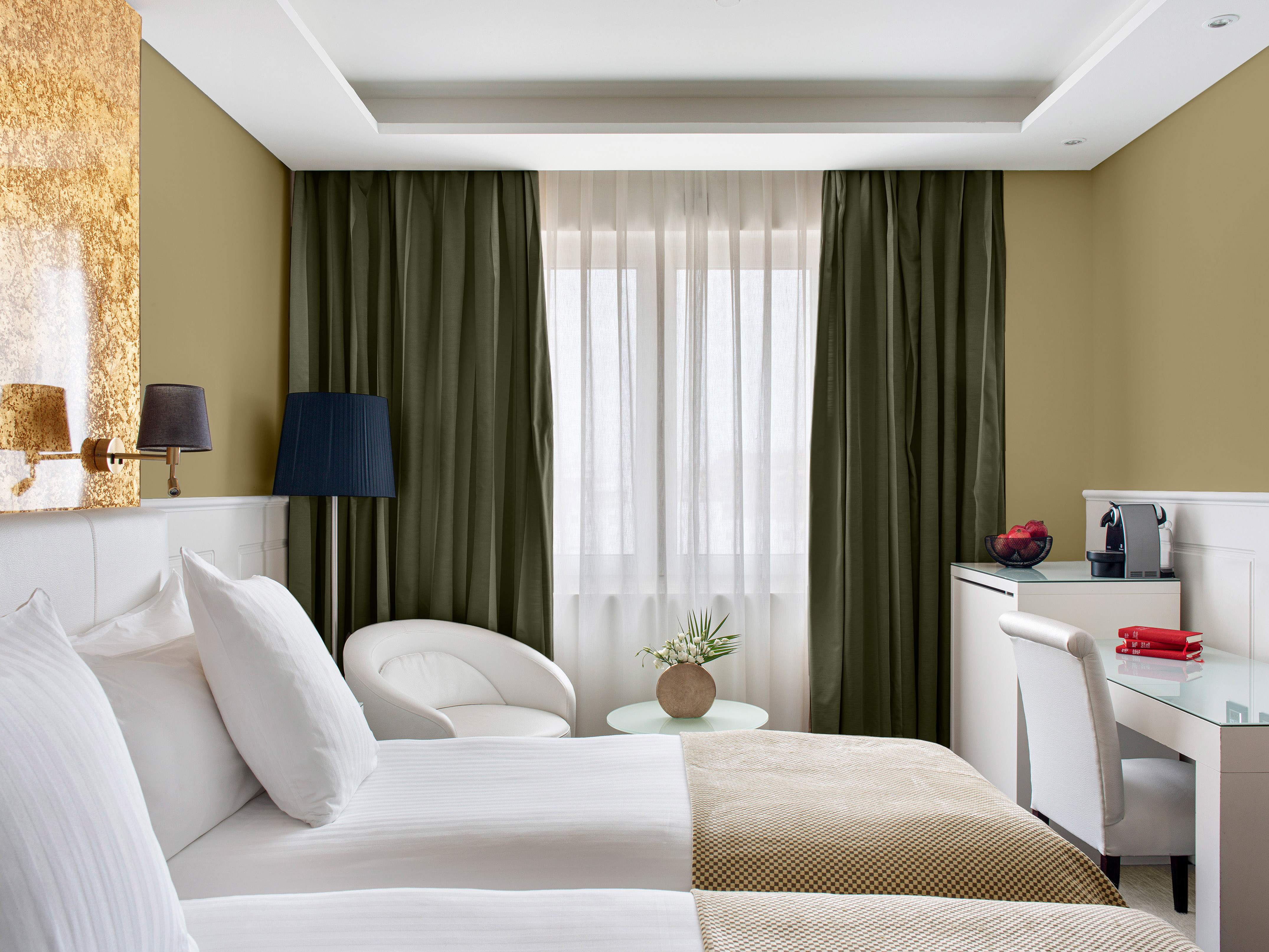 a room with two beds and a table with a lamp and a plant