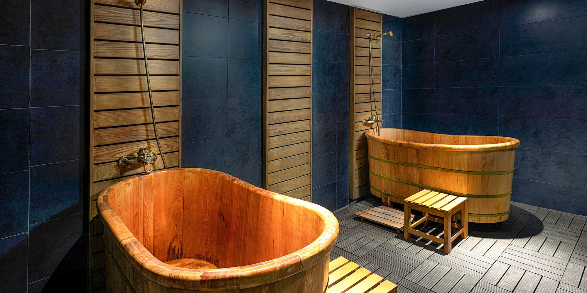 a bathroom with wooden tubs and a bench