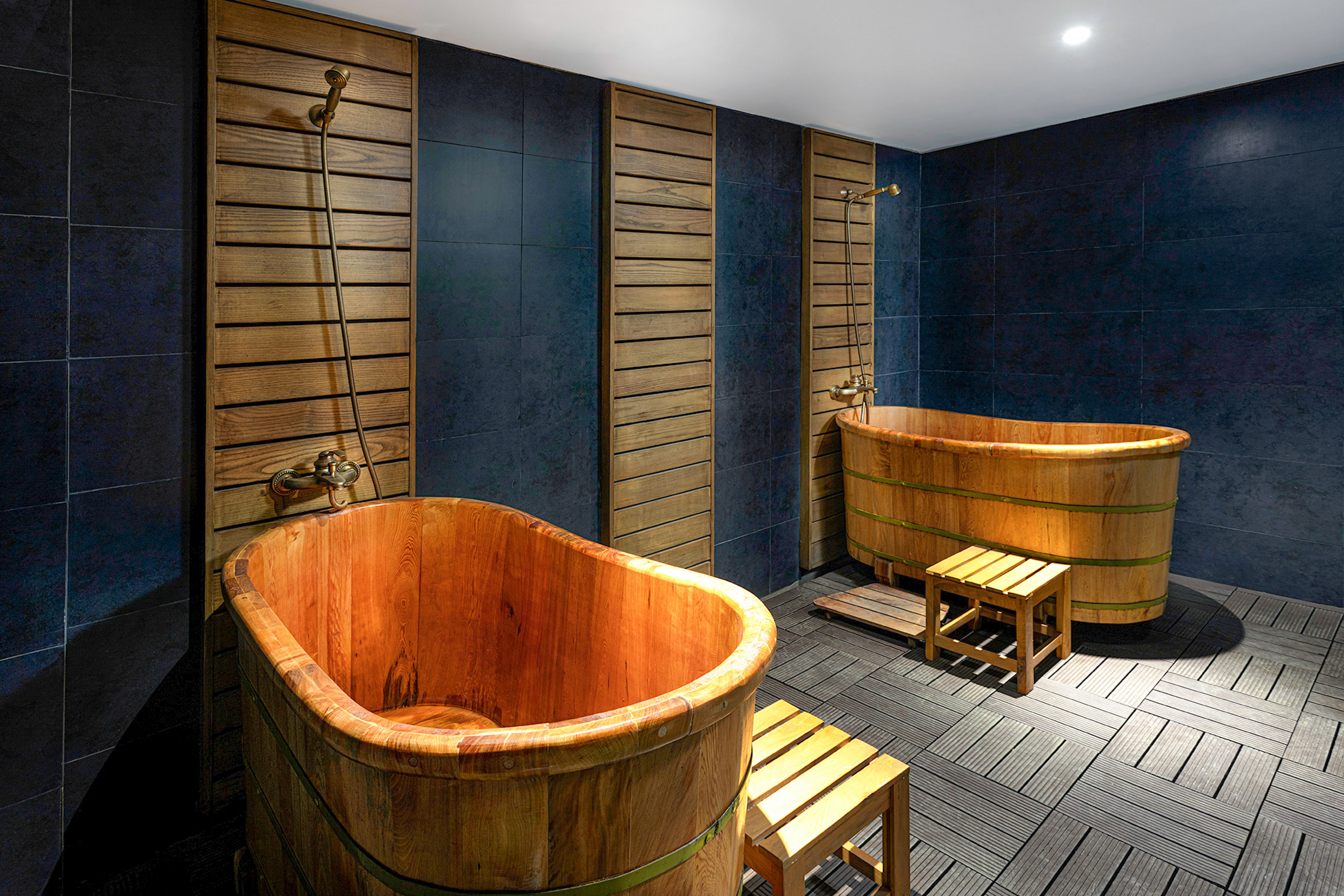 a bathroom with wooden tubs and a bench