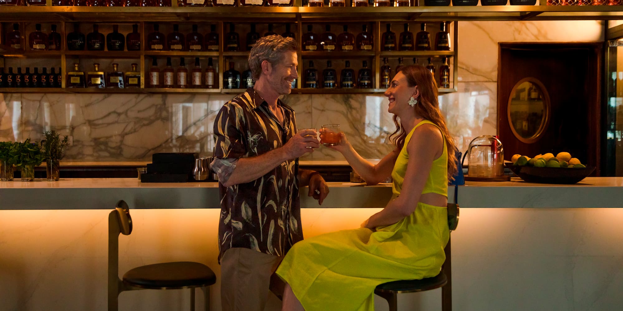 a man and woman sitting at a bar