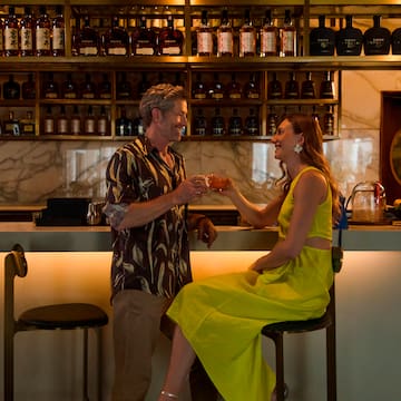 a man and woman sitting at a bar