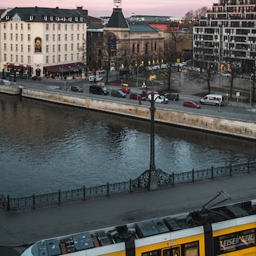 a river with a bridge and cars and buildings