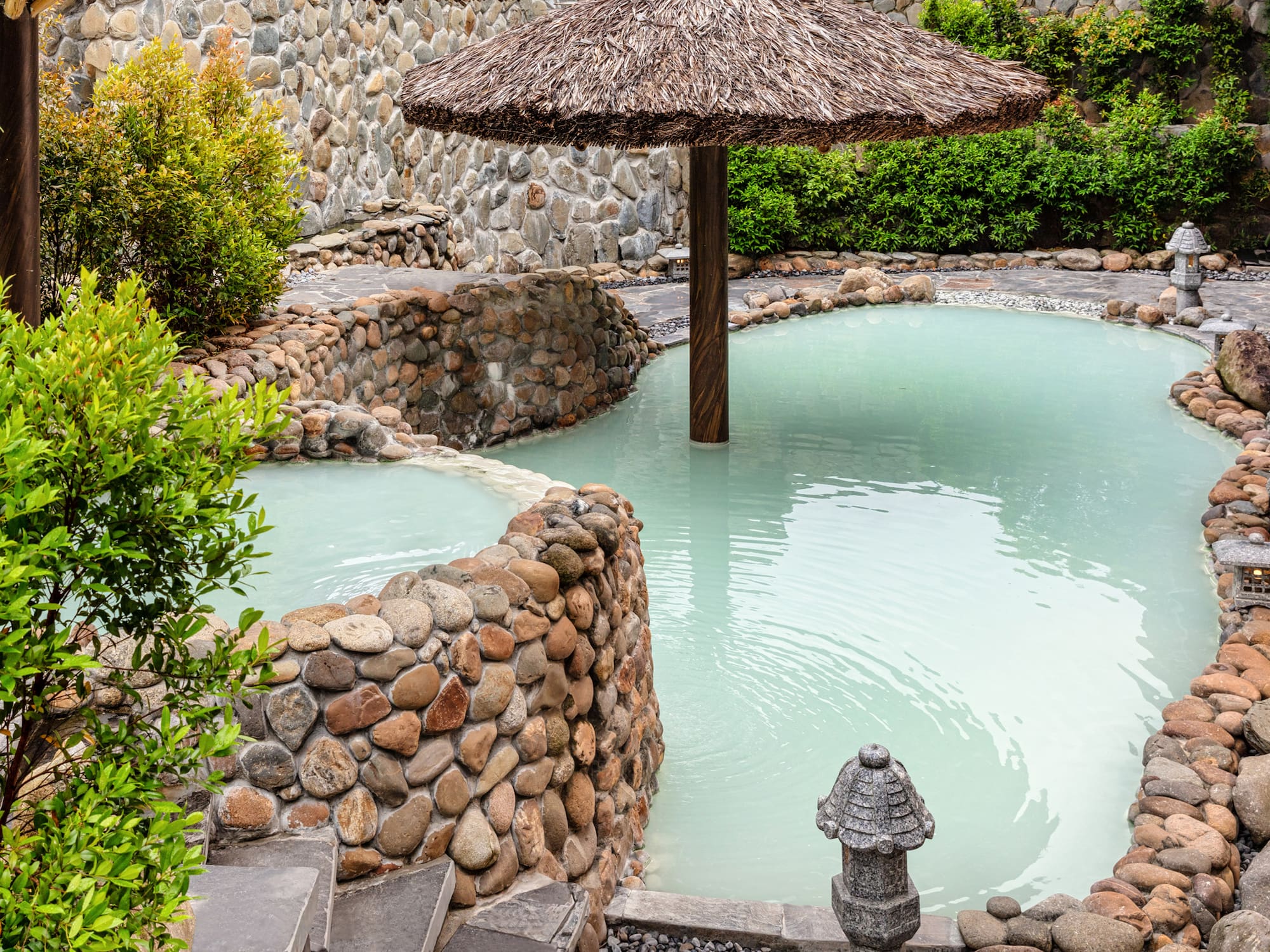 a pool with a straw umbrella