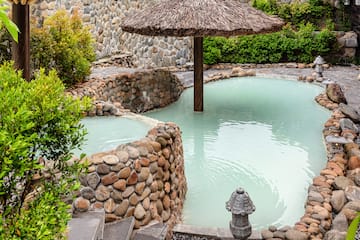 a pool with a straw umbrella