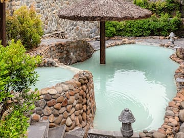 a pool with a straw umbrella