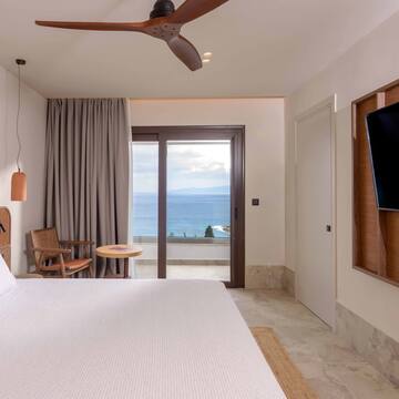 a room with a large bed and a television and a window