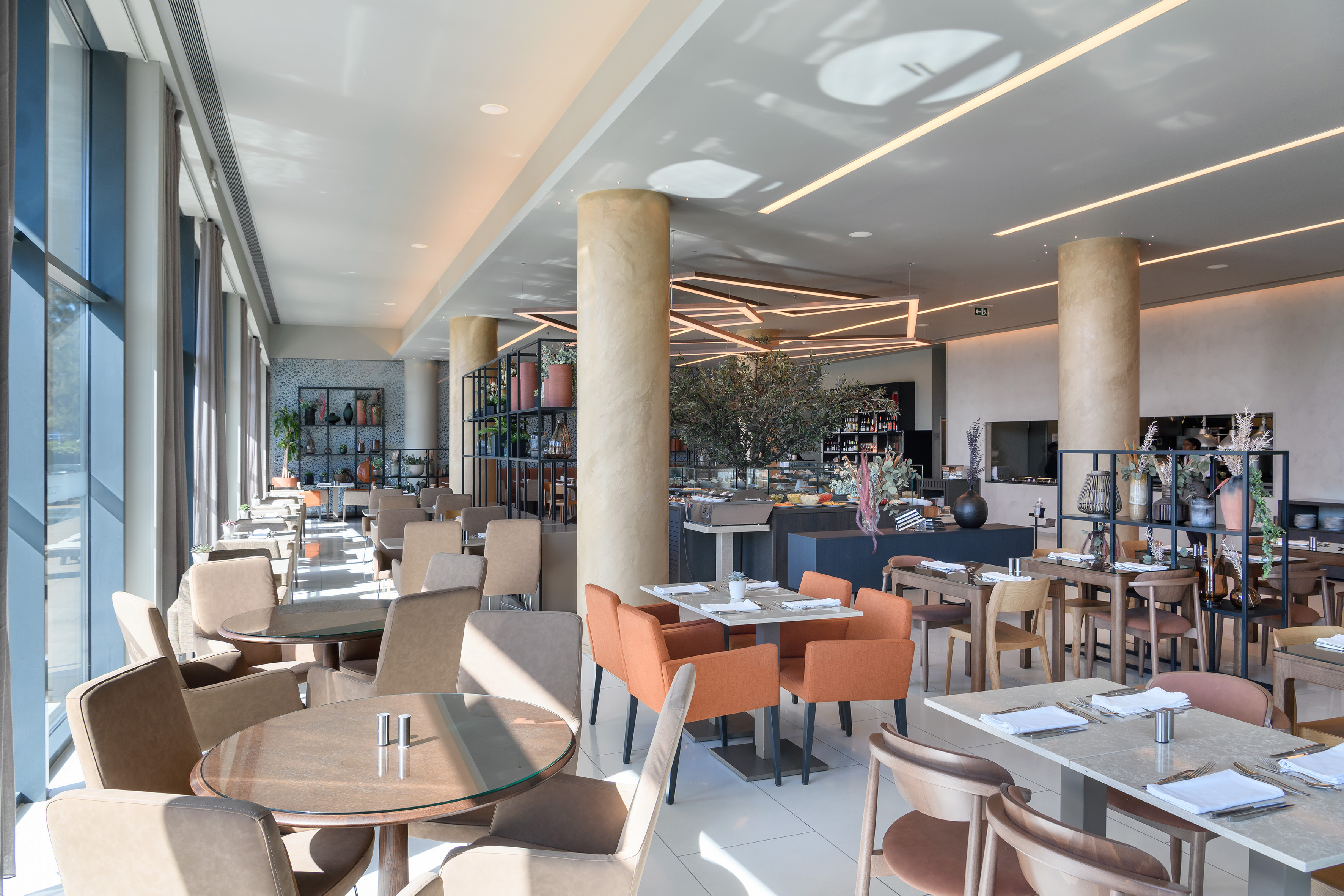 Modern restaurant interior with stylish seating, buffet area, and bright windows.